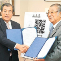 協定書に調印し握手を交わす三島市長と弊財団代表理事